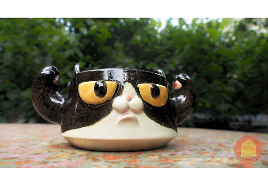 Cute clay cat mug with expressive yellow eyes and playful design, perfect for crafting enthusiasts.