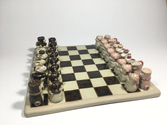 Handcrafted clay chess set with cute animal pieces on a checkered board